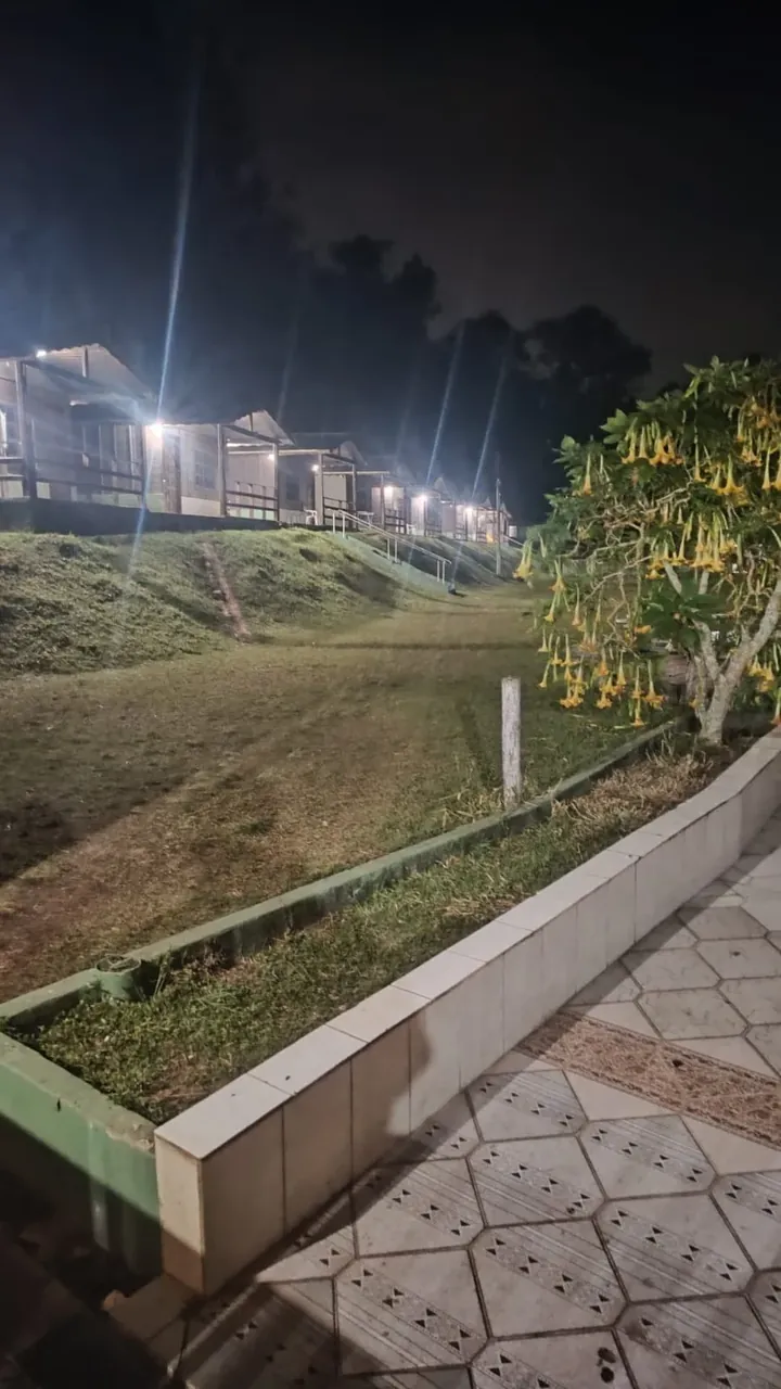 Espaço externo arborizado da VilaCare com área de convivência